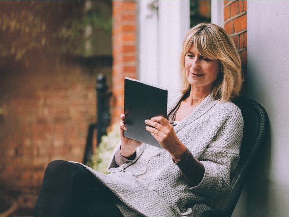 Frau ließt Zeitung auf Tablet